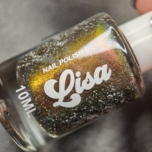 May include: A 10 ml bottle of nail polish with a gold and green iridescent shimmer. The bottle is labeled "Nail Polish by Lisa".