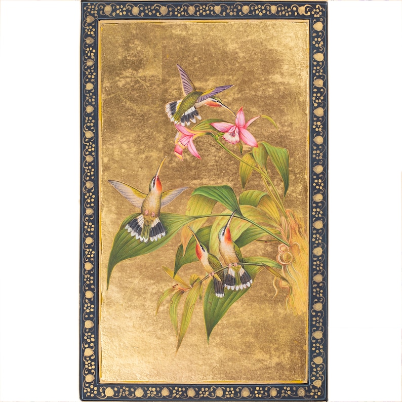 Puede incluir: Una pintura de tres colibr&iacute;es en vuelo, con un fondo dorado y un marco negro. Los colibr&iacute;es est&aacute;n representados con intrincados detalles, y la pintura es un hermoso ejemplo del arte tradicional indio.
