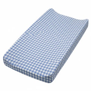 May include: A blue and white gingham patterned changing pad. The pad is rectangular with curved edges and a raised headrest. The fabric has a classic checkered design, perfect for a nursery.