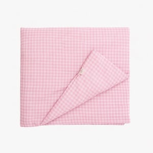May include: A pink and white gingham patterned blanket, folded neatly. The blanket is made of a soft fabric and has a classic, timeless design. The corner of the blanket is folded over, revealing the underside of the fabric.