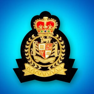 May include: A black and gold embroidered patch featuring a crown, shield, and banner. The shield is red, white, and gold with a lion on each side. The banner is gold with a black inscription.