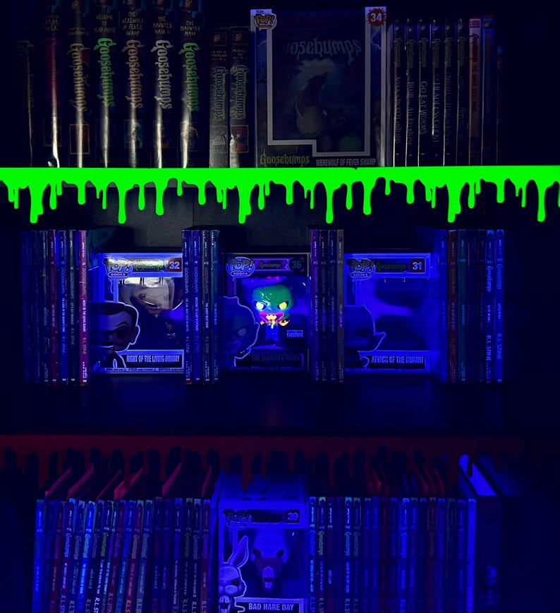 May include: A shelf featuring Goosebumps books and Funko Pop figures, lit with blue light. The spines of the books and the figures are visible. A green slime design decorates the top shelf. The image includes the text "Goosebumps".