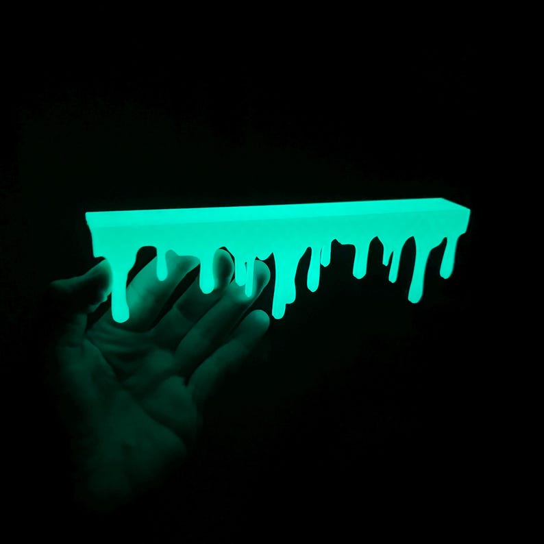May include: A neon green, rectangular object with a dripping design, set against a black backdrop. The object glows brightly, with the dripping effect creating a unique, artistic appearance. The overall theme is a modern, abstract design, with a striking visual impact.