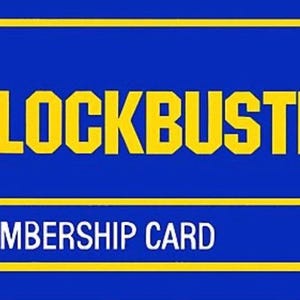 May include: A blue and yellow membership card for Blockbuster Video. The card has the Blockbuster logo and the text "MEMBERSHIP CARD" on it. The website address www.blockbuster.com is printed on the right side of the card.