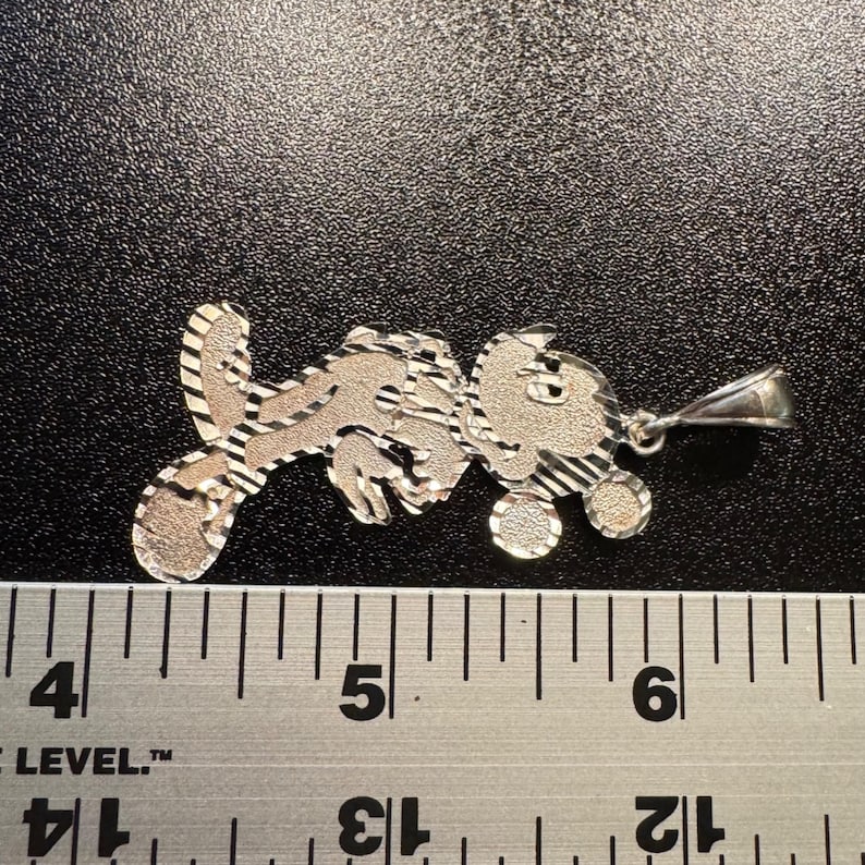 May include: A silver-toned metal pendant shaped like a cartoon mouse character with a textured, diamond-cut finish. The pendant is positioned above a metal ruler, showing a width of approximately 4.5 cm from the left edge to the bail.