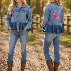 May include: A light blue denim jacket featuring a dark blue ruffled peplum hem, a button-up front, and a pink floral graphic on the chest and back. The jacket is paired with blue denim jeans and brown leather cowboy boots.