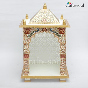 以下が含まれることがあります： 白と金の装飾的な寺院で、複雑な花柄と孔雀のデザインが施されています。 寺院はピラミッド型の屋根とアーチ型の入り口を備え、「craft by soul」の文字が見えます。