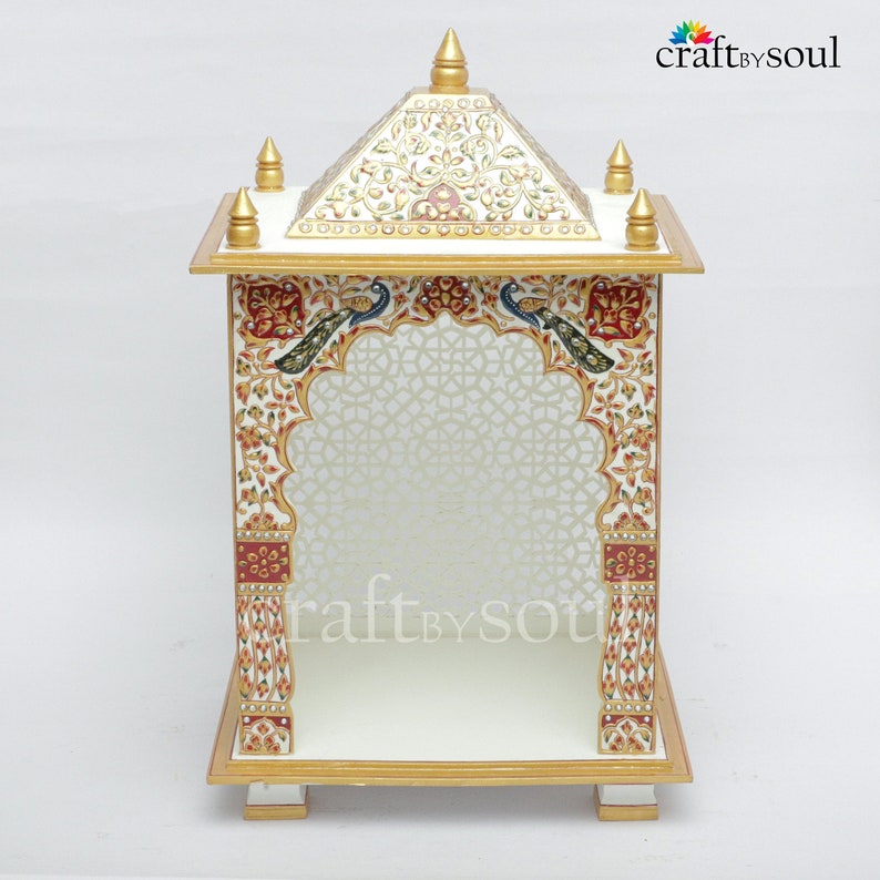 以下が含まれることがあります： 白と金の装飾的な寺院で、複雑な花柄と孔雀のデザインが施されています。 寺院はピラミッド型の屋根とアーチ型の入り口を備え、「craft by soul」の文字が見えます。