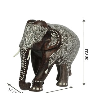 Puede incluir: Figura decorativa de elefante de madera, de 30 cm de alto, 32 cm de largo y 17 cm de ancho, con intrincados patrones de incrustaciones blancas. El elefante marr&oacute;n oscuro tiene colmillos blancos y es un art&iacute;culo artesanal.
