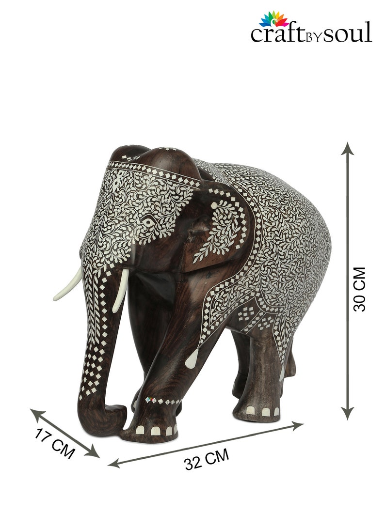 Puede incluir: Figura decorativa de elefante de madera, de 30 cm de alto, 32 cm de largo y 17 cm de ancho, con intrincados patrones de incrustaciones blancas. El elefante marr&oacute;n oscuro tiene colmillos blancos y es un art&iacute;culo artesanal.