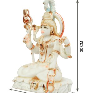May include: A white and gold statue of a seated deity, 11 cm wide, 18 cm long, and 30 cm tall. The statue features multiple arms, ornate jewelry, and a trident. The base of the statue has a lion's head. The product is from craftbysoul.