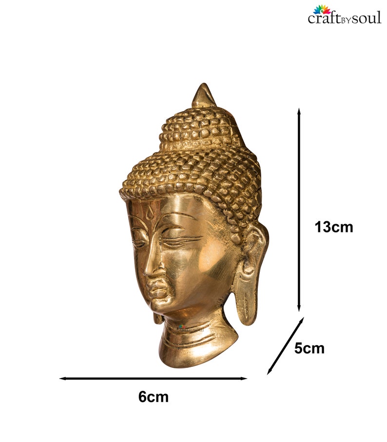 Puede incluir: Una escultura de cabeza de Buda dorada. La escultura mide 13 cm de alto, 6 cm de ancho y 5 cm de profundidad. La cabeza presenta rasgos faciales detallados y una toca texturizada. El producto es de craftbysoul.