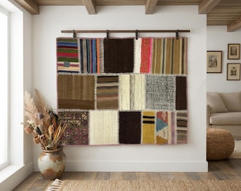 Pode incluir: Uma grande tapeçaria retangular de parede composta por vários retalhos de tecido costurados em cores diversas, incluindo castanho, creme, vermelho, azul e verde. O tecido apresenta um design de patchwork com costuras brancas visíveis.