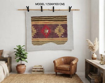 Puede incluir: Un tapiz rectangular de tejido textil con un patrón geométrico que presenta un motivo central de diamante rojo, flanqueado por formas de diamante color canela sobre un fondo morado oscuro, mide 124x103 cm y cuelga de una varilla de madera con clips negros.
