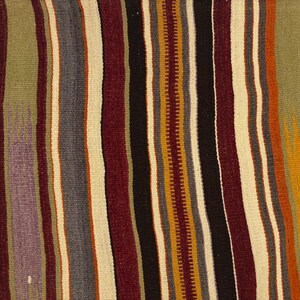 May include: A woven textile featuring a repeating pattern of vertical stripes in various colors including olive green, deep burgundy, charcoal gray, cream, mustard yellow, and black. The fabric displays a textured, flat-weave appearance.