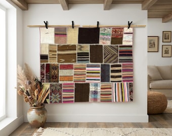 Puede incluir: Un tapiz rectangular compuesto por varios parches de tela cosidos en diversos colores, incluyendo marrón, negro, rojo y azul. El textil presenta una cuadrícula de segmentos rectangulares con patrones a rayas, sólidos y geométricos.