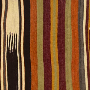 May include: A woven textile featuring vertical stripes in shades of mustard yellow, deep burgundy, olive green, black, and cream. The fabric displays a textured surface with small, repeating rectangular patterns integrated into the striped design.