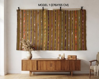 May include: A large rectangular wall hanging featuring vertical stripes in shades of olive green, brown, and orange with small white accents. The textile is suspended from a wooden rod by black clips and is labeled as Model 1 (276x155 cm).