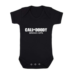 Puede incluir: Un body negro para bebé con texto blanco que dice "CALL OF DOODY BROWN OPS".