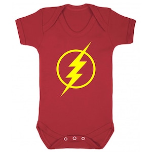 May include: Red baby onesie with a yellow lightning bolt symbol in a circle. The symbol is the logo for the Flash.
