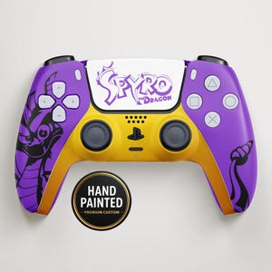 May include: A custom-painted video game controller in purple and yellow. The controller features the text "Spyro the Dragon" and a dragon graphic. The controller also has the text "Hand Painted - Premium Custom" on a circular sticker.