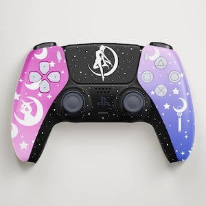 Op de afbeelding: Een aangepaste PlayStation 5-controller met een zwart midden en roze tot blauwe gradiënt zijkanten. De controller heeft een Sailor Moon-thema met sterren, manen en een karaktersilhouet.