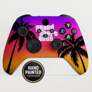 May include: Custom hand-painted Xbox controller with a vibrant sunset design featuring palm trees and the text "Grand Theft Auto." The controller has black buttons and a circular "Hand Painted" sticker.