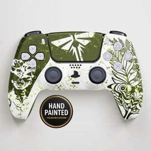 Può includere: Controller di gioco personalizzato dipinto a mano. Il design presenta una combinazione di colori verde e bianco con un tema ispirato alla natura, tra cui illustrazioni di foglie e insetti. Il controller ha un adesivo nero e oro "Hand Painted - Premium Custom".