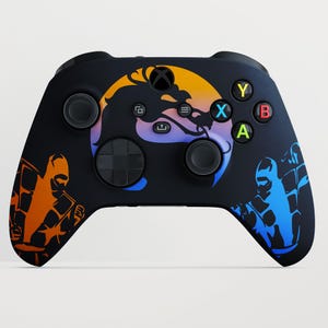 Könnte beinhalten: Schwarzer Xbox-Controller mit farbenfroher Grafik eines Drachen und zwei Figuren in Orange und Blau. Der Controller hat farbige Tasten und ein Steuerkreuz.