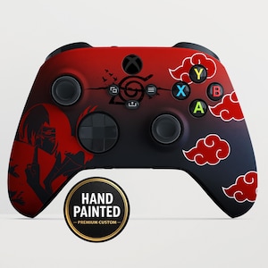 Può includere: Controller Xbox dipinto a mano personalizzato con un design sfumato rosso e nero. Presenta una silhouette di personaggio, accenti di nuvole rosse e il testo "HAND PAINTED - PREMIUM CUSTOM".
