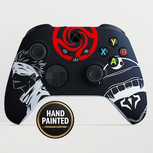 May include: Black Xbox controller with custom artwork. Features a red spiral design, white character illustrations, and colorful buttons. Includes a "Hand Painted - Premium Custom" sticker.