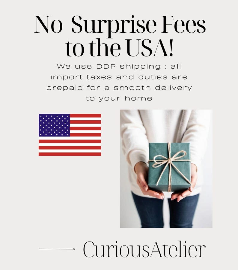 May include: Image features the text "No Surprise Fees to the USA!" and the American flag. A person holds a teal gift box tied with twine. The shop name "CuriousAtelier" is at the bottom.