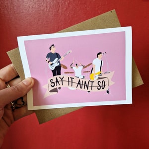 May include: A pink greeting card with a cartoon illustration of a band playing music. The band has three members, and the card says "Say It Ain't So".
