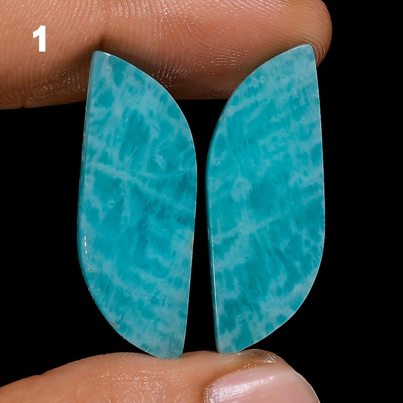 May include: A pair of teal blue amazonite cabochons with a white marbled pattern. The cabochons are shaped like a leaf and are approximately 2 inches long.