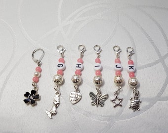 Silver Alpha stitch markers with pink beads, silver beads, charms on lobster clasps. Bonus progress keeper "When size matters" range