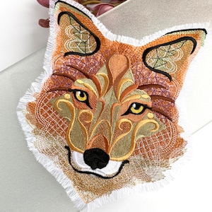 May include: Embroidered fox head patch featuring intricate details in shades of brown, gold, and white. The fox's eyes are yellow and the nose is black.