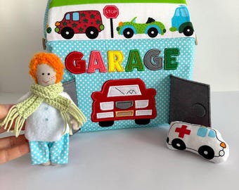 Casa de muñecas de tela hecha a mano con garaje, muñeco y coche de juguete.