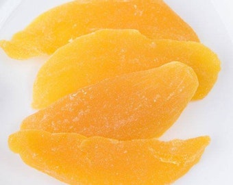 May include: Four slices of dried mango, featuring a vibrant orange-yellow hue. The fruit pieces are arranged on a white surface, showcasing their textured, slightly wrinkled appearance. A close-up shot highlights the natural color and shape of the dried fruit.