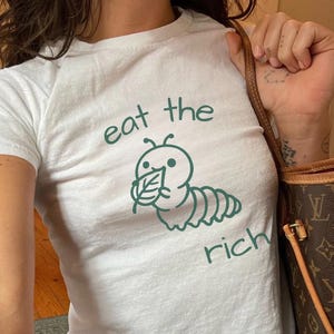 コケット 金持ちを食べる かわいい芋虫 レトロ フェミニスト ベビーTシャツ フェミニズム Y2K クロップドTシャツ 90年代 平等 女性のエンパワーメント 皮肉な格言