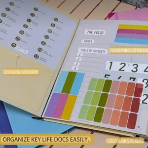 May include: An open document organiser folio featuring a table of contents, labelled sections, and included sticker sheets. The set contains 33 label stickers, 12 number stickers, and 35 colour stickers in various shades of green, pink, and red.