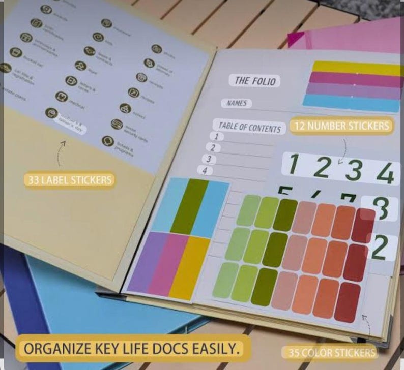May include: An open document organiser folio featuring a table of contents, labelled sections, and included sticker sheets. The set contains 33 label stickers, 12 number stickers, and 35 colour stickers in various shades of green, pink, and red.