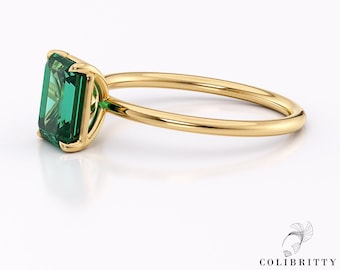 Op de afbeelding: Een gouden ring met een grote smaragdgroene edelsteen in een kraalbezetting.