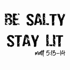 以下が含まれることがあります： 白地に黒文字で「BE SALTY STAY LIT」と「matt 5:13-14」と書かれた画像。 文字はかすれた質感で、ヴィンテージまたはグランジスタイルを連想させる。 デザインはシンプルで大胆。