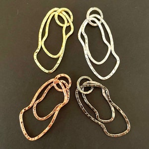 May include: Four pairs of earrings in different colors: gold, silver, rose gold, and black. Each pair is made of two overlapping, textured, irregular shapes.