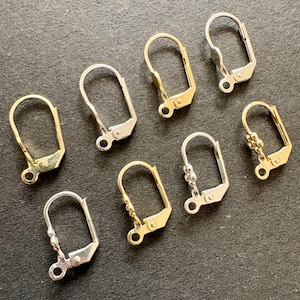 Op de afbeelding: Een verzameling van zeven oorbelonderdelen met een leverback-sluiting. De set bevat zowel zilverkleurige als goudkleurige componenten, waarvan sommige kleine decoratieve kraalaccenten hebben bij de basisring voor het bevestigen van bedels.