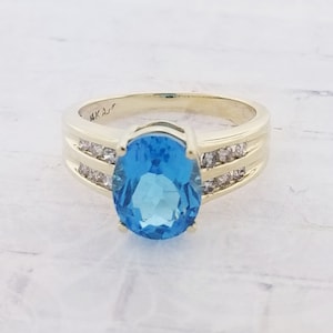 Anillo de oro amarillo de 14 k con topacio azul y diamantes