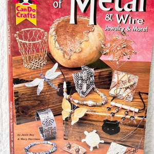May include: A book titled "ABC's of Metal & Wire Jewelry & More!" by Janie Ray & Mary Harrison. The book cover features a variety of metal and wire jewelry projects, including a basket, a necklace, earrings, a bracelet, and a turtle.