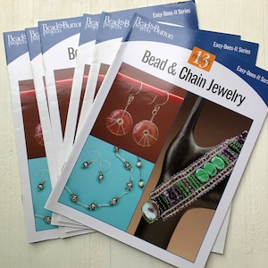 May include: A stack of 13 bead and chain jewelry project books from Bead & Button Projects. The cover of the top book features a black shoe with a green and purple beaded bracelet and a turquoise background with a pair of earrings and a necklace.