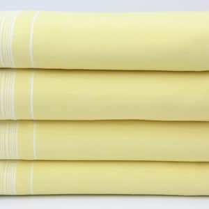 May include: A stack of four yellow beach towels with white fringe. The towels have white stripes.