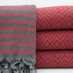 May include: Two Turkish towels, one with red and grey stripes and the other with a red and grey diamond pattern.